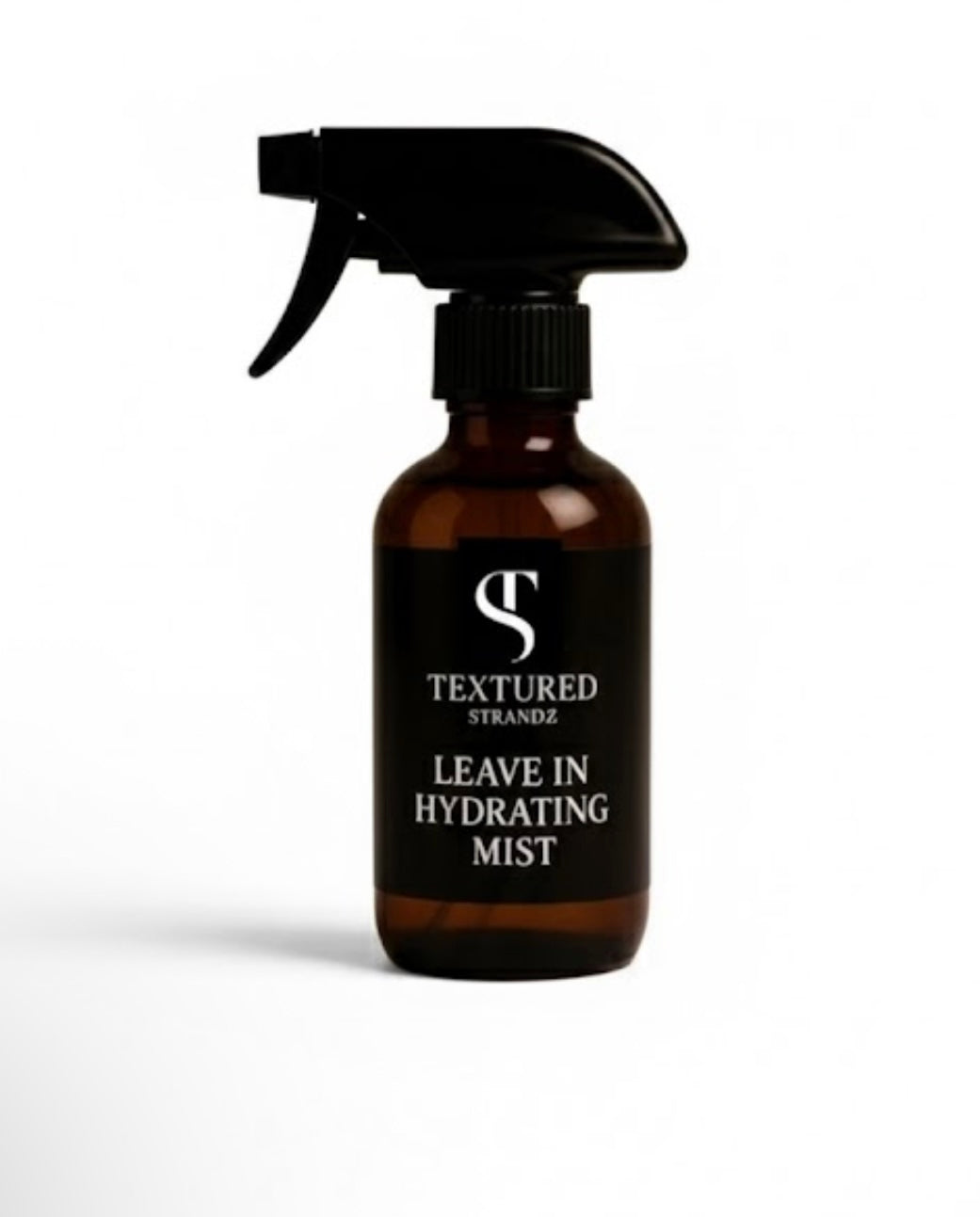 Brown spray bottle with black nozzle labeled 'Textured Strandz Leave In Hydrating Mist' on a white background