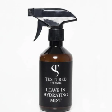 Black spray bottle labeled 'Textured Strandz Leave In Hydrating Mist' on a white background